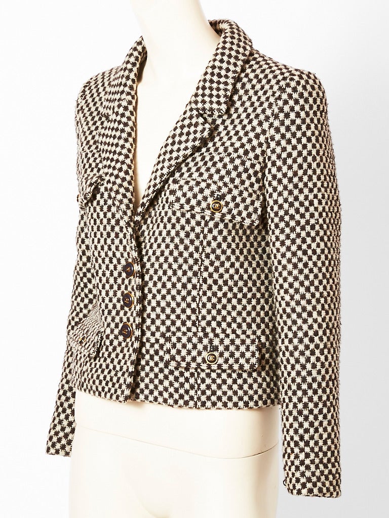 Chanel, brown and ivory, tweed, cropped jacket having signature Chanel, four pockets. Narrow collar is notched. Body is slightly fitted. Signature CC buttons.
Fall 1995 collection.