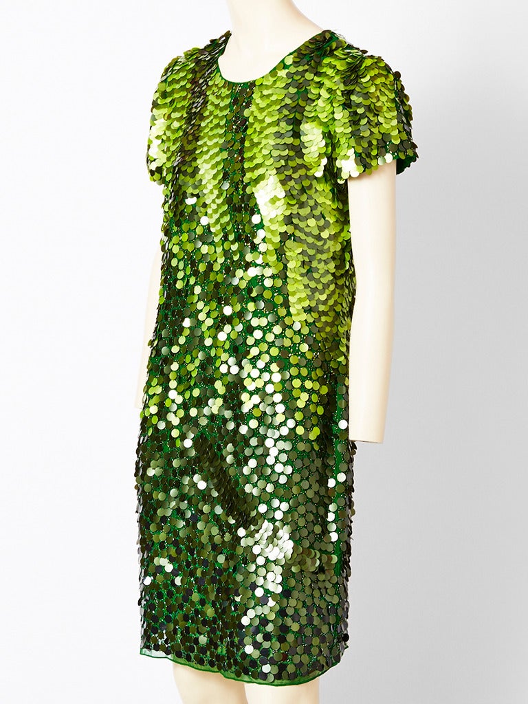 John Galliano, green chiffon tee shirt dress, encrusted with large paliettes that 
go from dark green to lighter green in the same tonal  range.
Dress has a jeweled neckline with short sleeves and slightly fitted body.