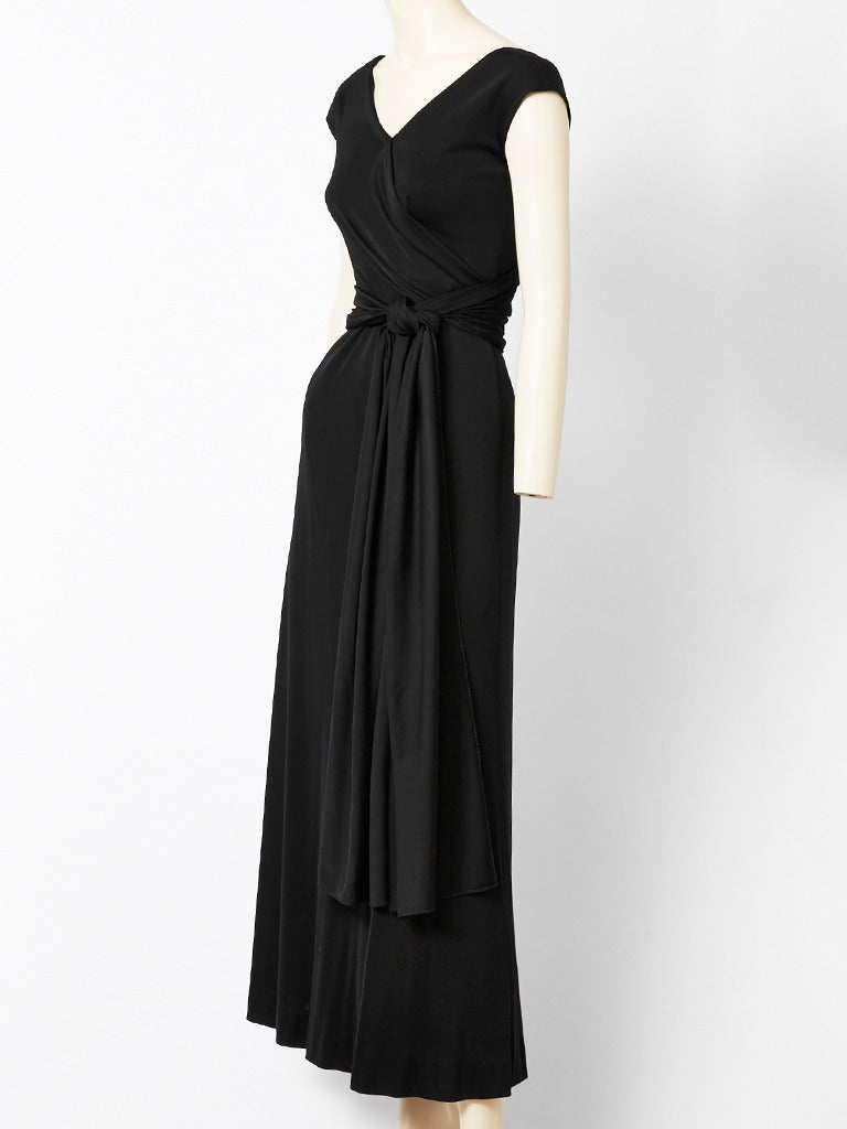 Mollie Parnis, jersey, maxi dress with bias cut skirt having a V neckline and cap sleeves and an attached wrap around belt that ties.