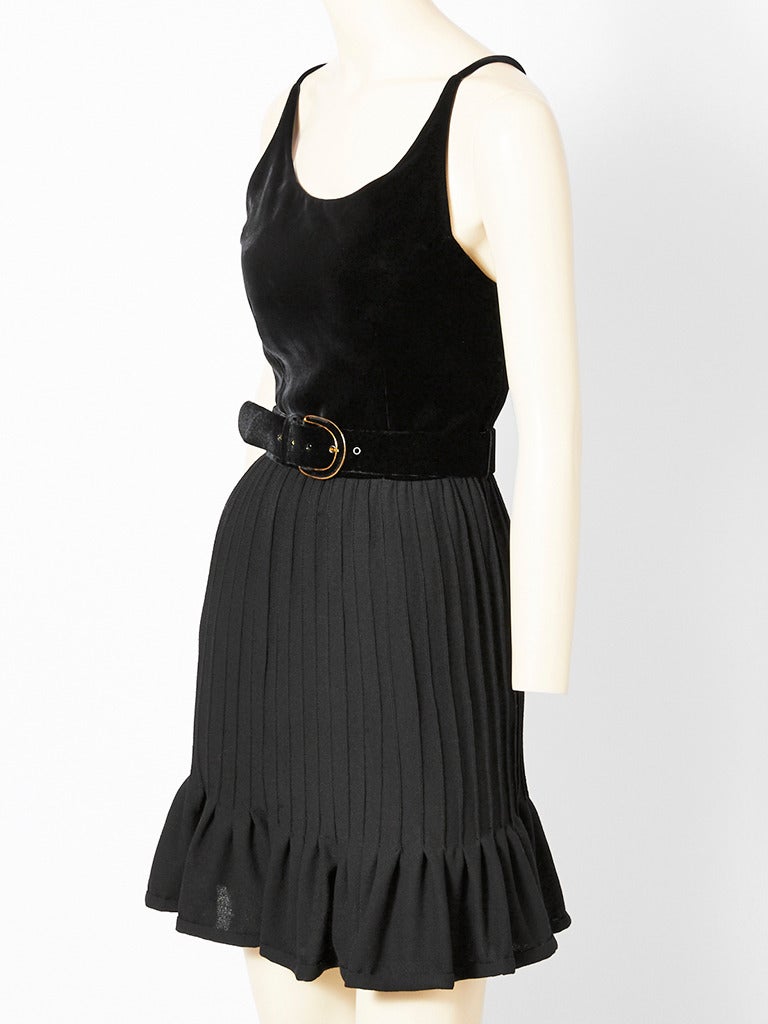 Valentino, black wool crepe and velvet, belted cocktail dress.
Dress has a fitted, sleeveless, scooped neck, velvet bodice with thin spaghetti straps that criss cross in the back. Belt is velvet. Skirt is a wool crepe with 
stitched down pleats