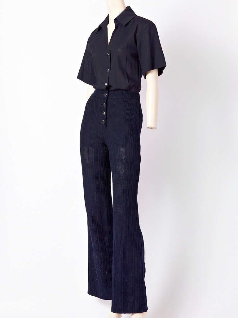 Chanel, nautical inspired, navy blue jumpsuit . Top is a short sleeve cotton voile that looks like a shirt. Bottom pant is wide legged in a heavy textured vertical knit.Buttons down the front with CC metal buttons.