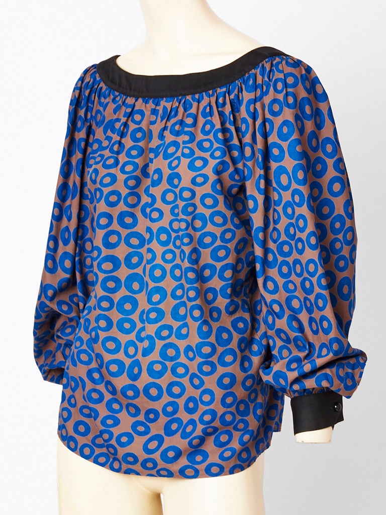 Yves Saint Laurent, cotton, smock blouse having a pattern on a pale brown background with indigo circles. Top has a scoop neckline. Neck and cuffs are edged in black.