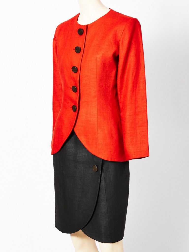 Yves Saint Laurent, 2 piece  skirt suit, having a collarless jacket in a persimmon color with a petal shaped hem.  Wrap skirt echoes the same hemline as the jacket in a black linen.