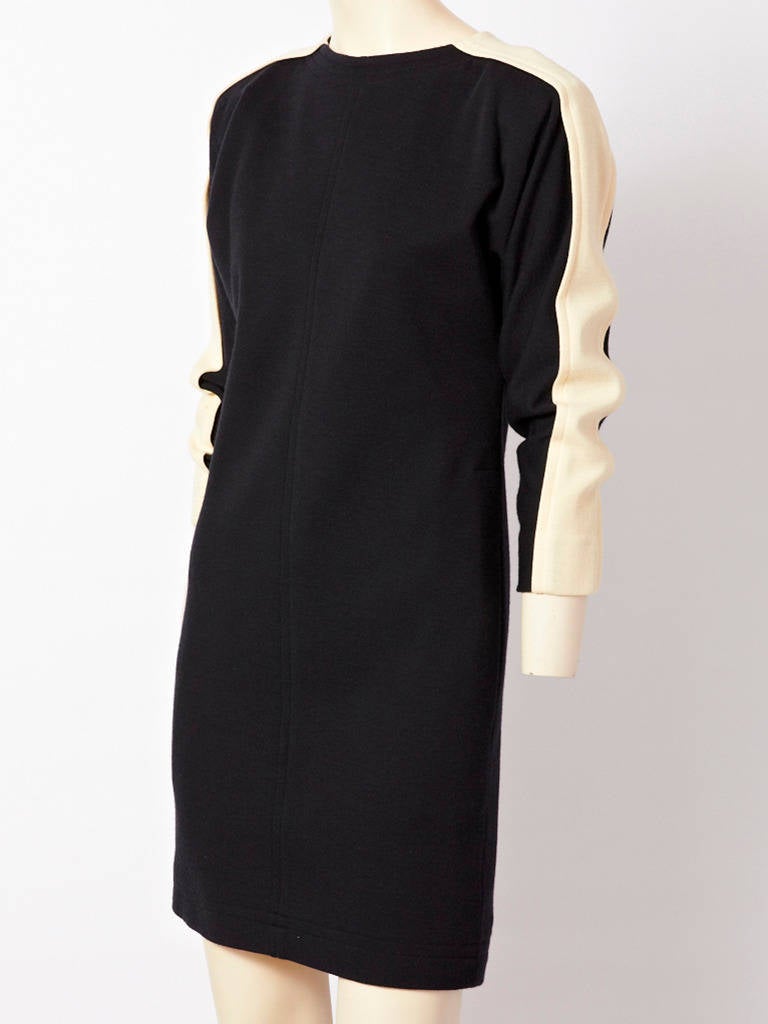 YSL, black, wool, knit, fitted dress with jewel neckline, hidden hip pockets,top stitching detail across the neckline, and hem. Dress has a ivory wool, knit inset,
that starts at the neckline and goes across the shoulder and down the middle of the