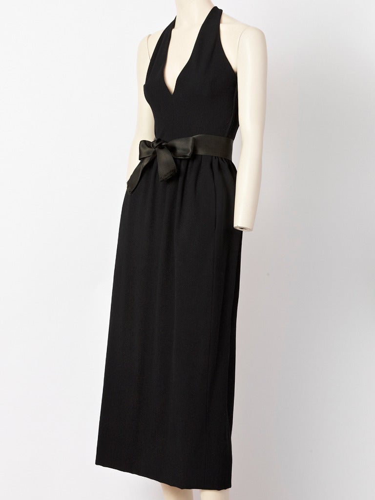 Norman Norell, wool, halter neck, gown with deep, plunging V neckline, slightly gathered waist, side seam pockets and satin belt.