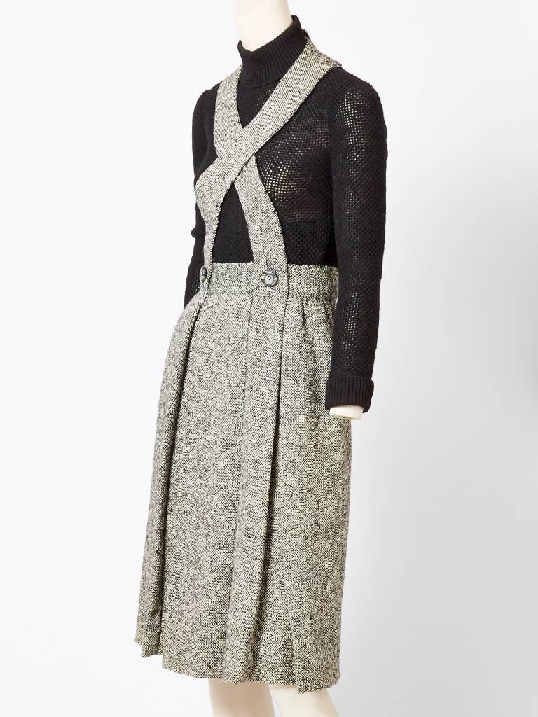Donald Brooks, wool knit and wool tweed combination day dress. This one piece dress is made to look a suspender skirt and ribbed sweater, however they are attached with a zippered back. Bodice of the dress is a black ,wool ,knit, ribbed, turtleneck