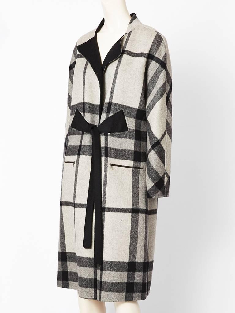 Ronaldus Shamask, double face wool reversible coat. Ivory and grays, plaid pattern on one side and black on the other side. Front has a tie at the front waist and leaves the back of coat free.