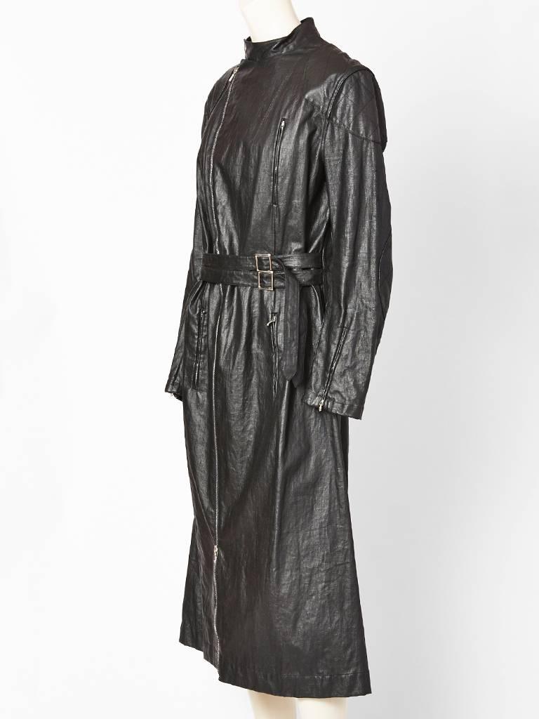 John Galliano, for Dior, black, waxed, linen, double, belted coat with  zipper closures going up the entire middle front of the coat. One zipper starts at the waist and goes up to the neck. The other zipper starts at the waist and goes down the