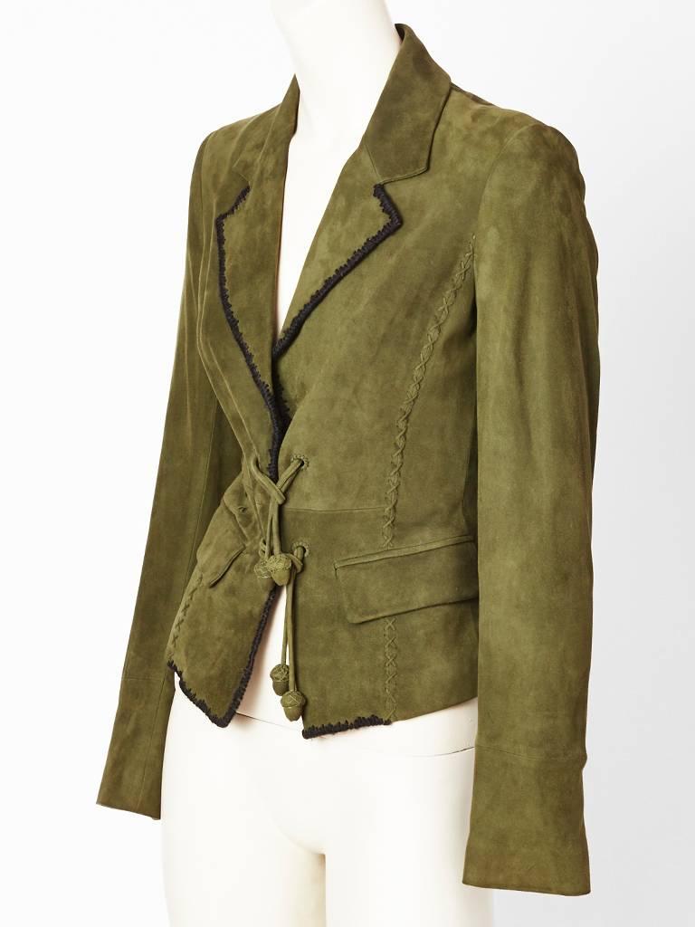 Tom Ford for Yves Saint Laurent, soft, olive green, suede, Tyrolean, inspired 
fitted jacket with black, vertical, cross stitch detail, along the sides. the lapels ,and hem. Flap pockets and laced ties to fasten the jacket. Ties end in acorn