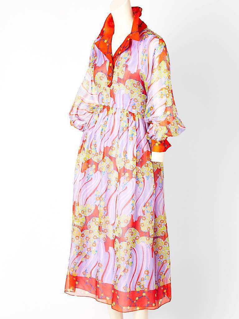 Oscar de la Renta, maxi dress in a silk organza, abstract print in pretty shades of tangerine, periwinkle blue and yellow. Bodice of the dress is shirt style with full sleeves that cuff at the wrist. Skirt is gathered. Late 60's early 70's.