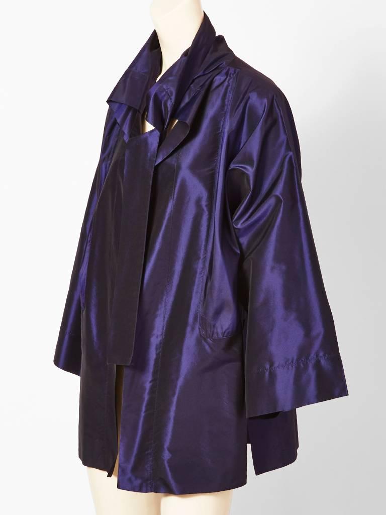Shamask, iridescent, silk taffeta, unlined, evening jacket, having a collar with ties at the ends. Kimono style, silhouette with side slits and wide sleeves that can be rolled up. Purplish tones. 