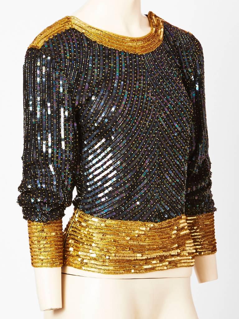 Yves Saint Laurent, iridescent, bugle beaded and sequined on silk top. Black body with gold cuffs, neckline and waistline. Sleeves are dolman shape.
C. 1980's. 
 