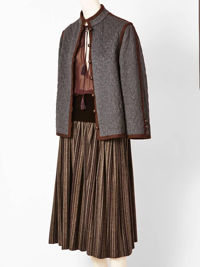 Yves Saint Laurent, 3 piece couture, Russian Collection, day ensemble.
Having a grey quilted jacket, lined in brown satin, with brown, passementerie trim. Blouse is 