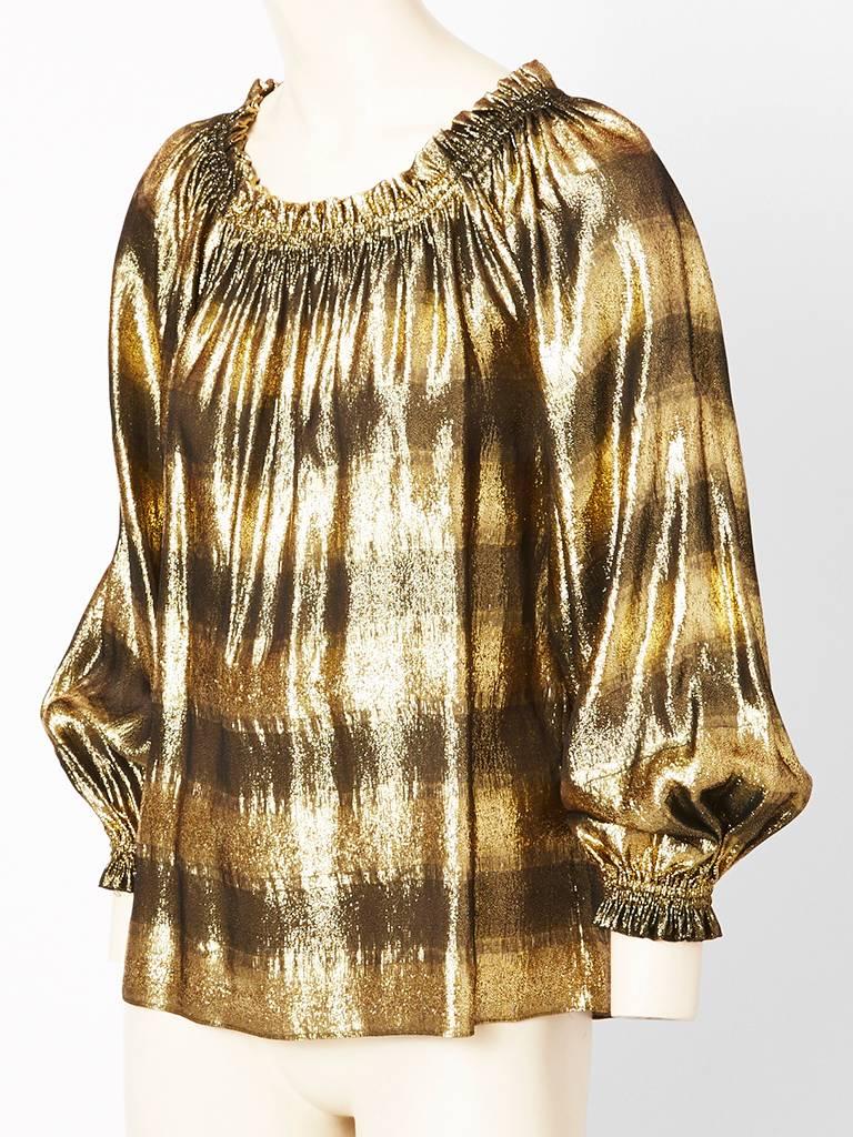 Yves Saint Laurent, gold lame, gypsy blouse with full sleeves having elasticized cuffs and neckline which can be worn off the shoulder. There is a dark ombred horizontal stripe creating a subtile pattern. Late 70's.