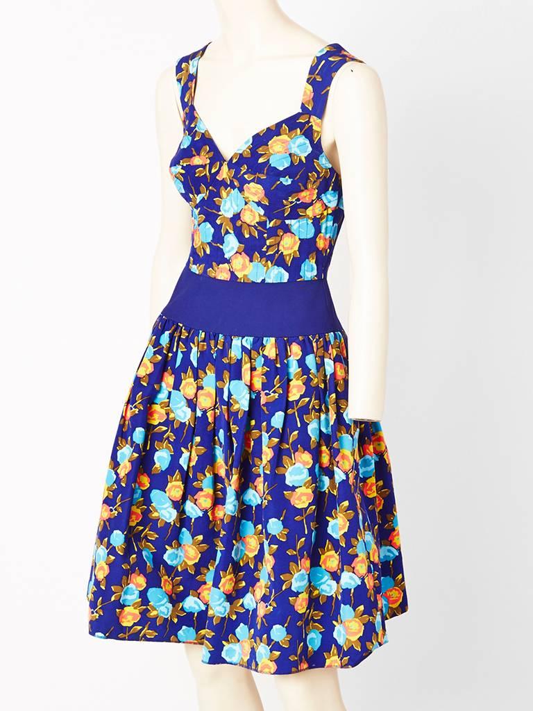 Yves Saint Laurent, silk, floral, pattern dress with a sweetheart neckline. 
Bodice is fitted with a blue color block, band starting at the waist and extends to the hip, where it sits snugly. Skirt is gathered. Back is open.