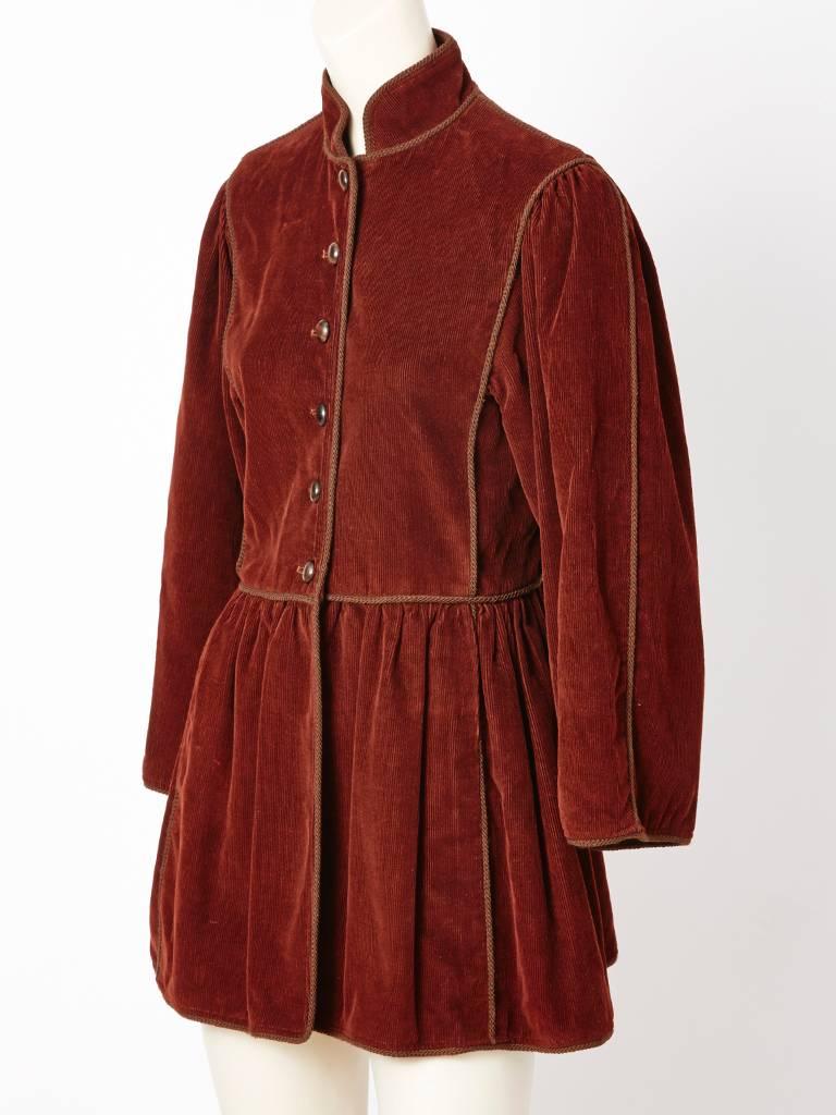 Yves Saint Laurent, rust, corduroy, Russian Collection jacket, c.late 70's.
Having a Mandarin collar, slightly dropped waist with gathering, braided cord trim in dark brown and wood buttons. Pockets are hidden.