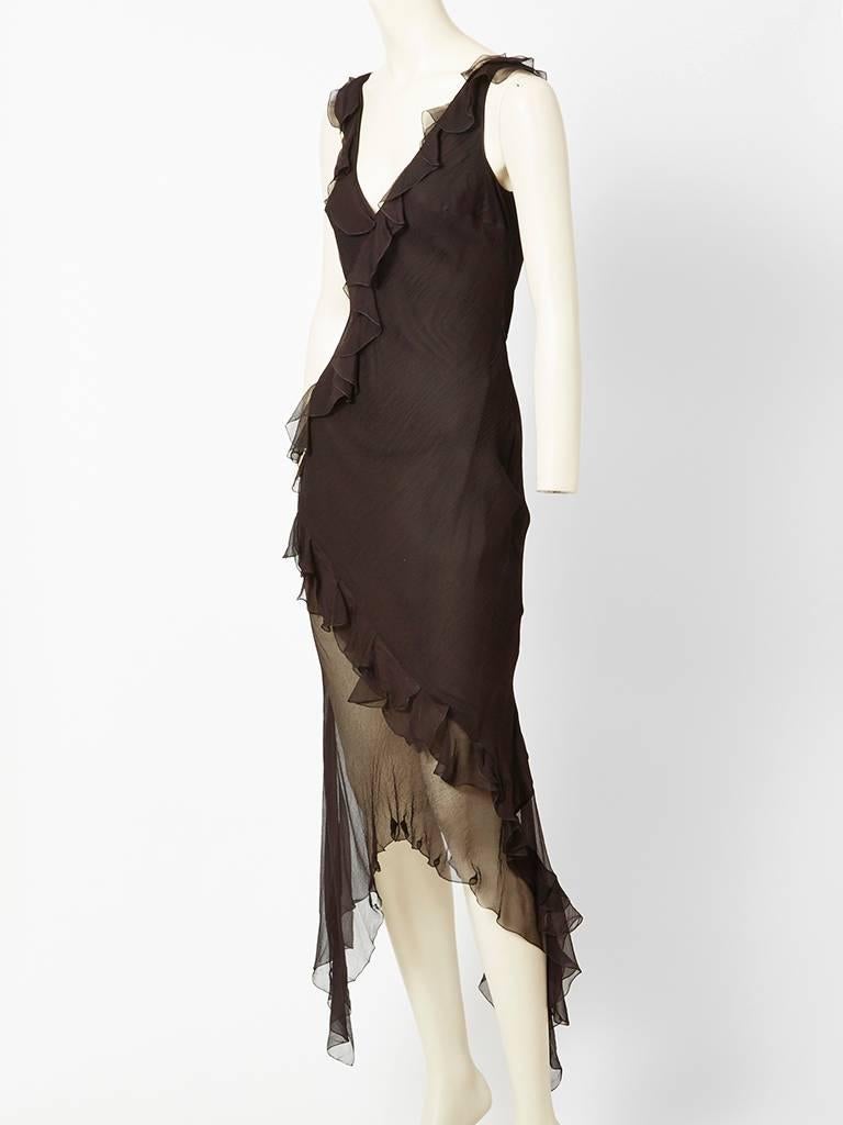 John Galliano, black chiffon, bias cut dress with ruffle detail and a sheer asymmetric hem, exposing the thigh and leg on one side. Dress has a deep v neckline with Ruffles placed diagnoly across the dress.