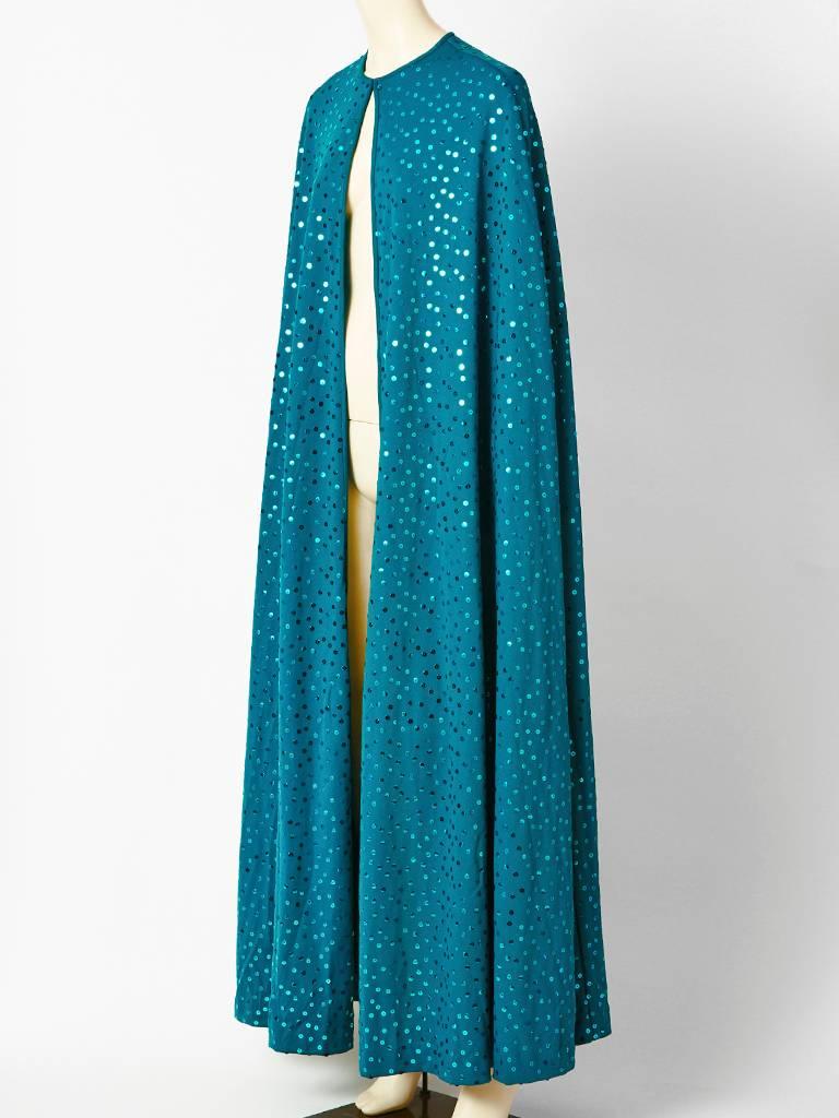 Clovis Ruffin, teal blue, matte jersey, floor length, cape, embellished throughout with sequins. Hook and eye closure at the neck. C. 1970's.