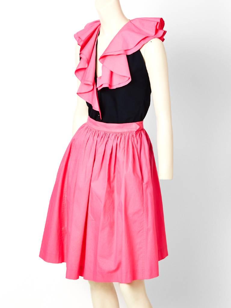 Yves Saint Laurent, pink and black, cotton ensemble. Sleeveless top with large,
exaggerated, flounced collar having a fitted bodice. Pink skirt, is gathered at the waist, having deep side pockets.