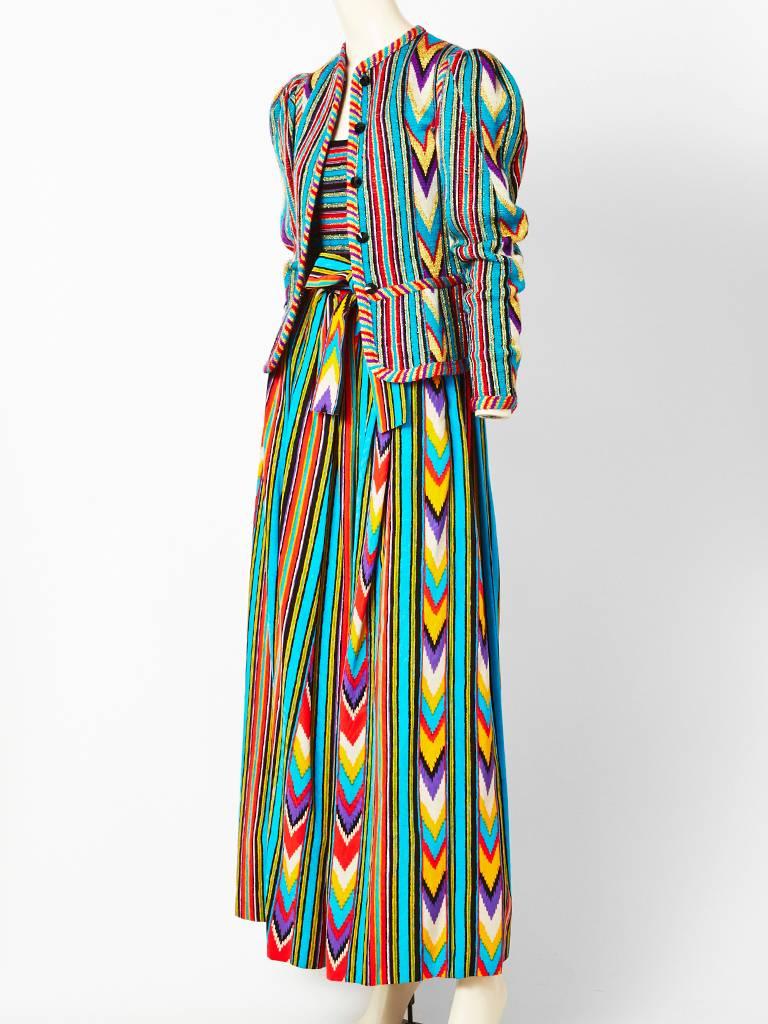 Yves Saint Laurent, three piece ensemble , composed of a moire faille with lurex, long skirt having an ikat inspired stripe pattern. Skirt has a matching sash. There is a wool knit horizontal stripe camisole and a cardigan with a peplum in a wool