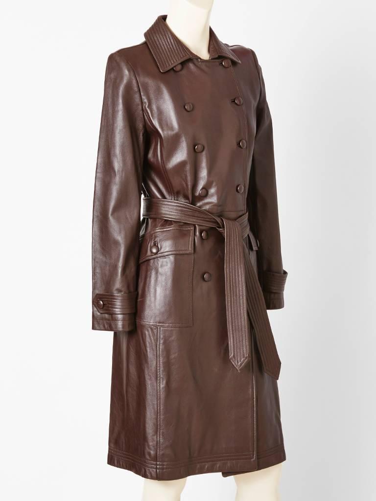Oscar de la Renta, chocolate brown, supple leather double breasted, belted,
trench. Top stitching detail at the cuff, belt, hem and collar. Deep flap side pockets.