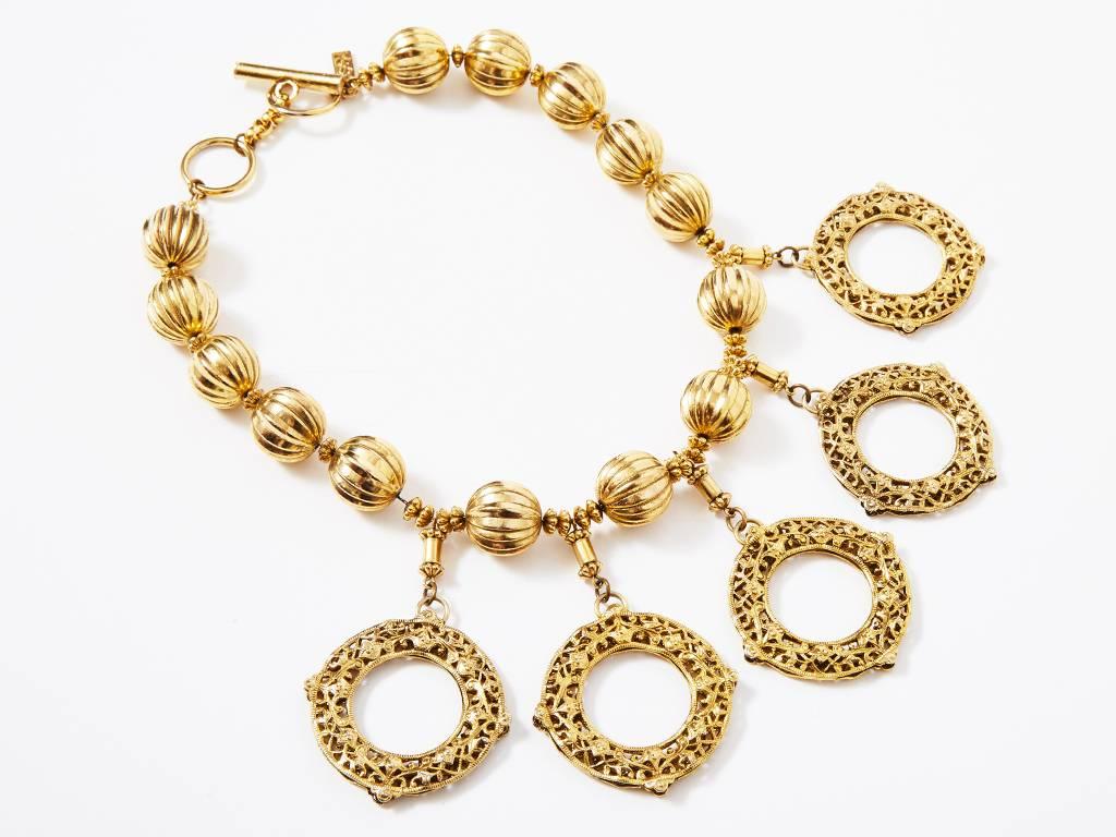 Yves Saint Laurent, gold tone, necklace having 5 dangling, filigree discs  hanging off a demi choker of fluted balls that are strung on a chain.