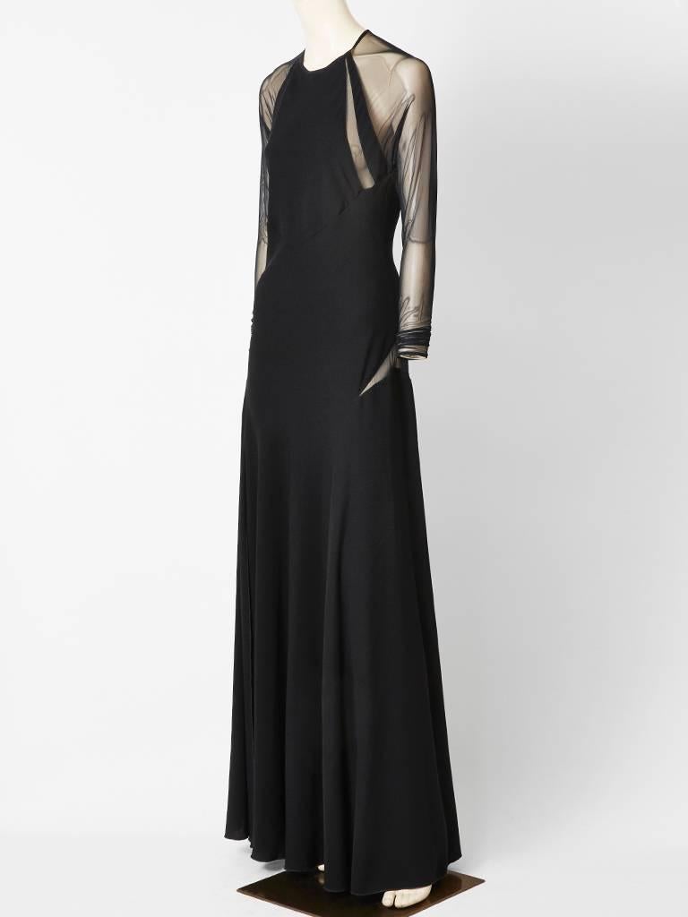 Jackie Rogers, bias cut, satin back, crepe, gown, having a jeweled neckline, with halter cut shoulders having sheer , stretch, net inserts, and  sleeves. Back is low cut with sheer net.Dress has slits that go up to the thigh.