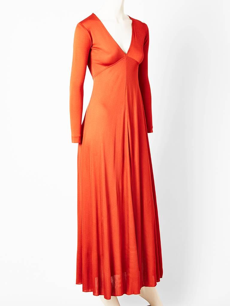 Scott Barrie, rust tone, long sleeved maxi dress, having a V neckline and bias cut panels giving a drapery effect. C. 1970's.