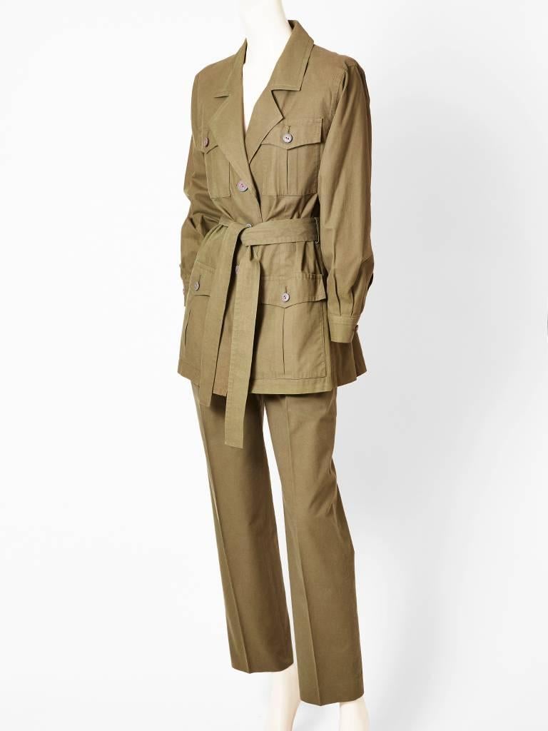 Yves Saint Laurent, olive green, cotton, safari style pant suit. Jacket is belted with lapels and breast and hip pockets. C.1990