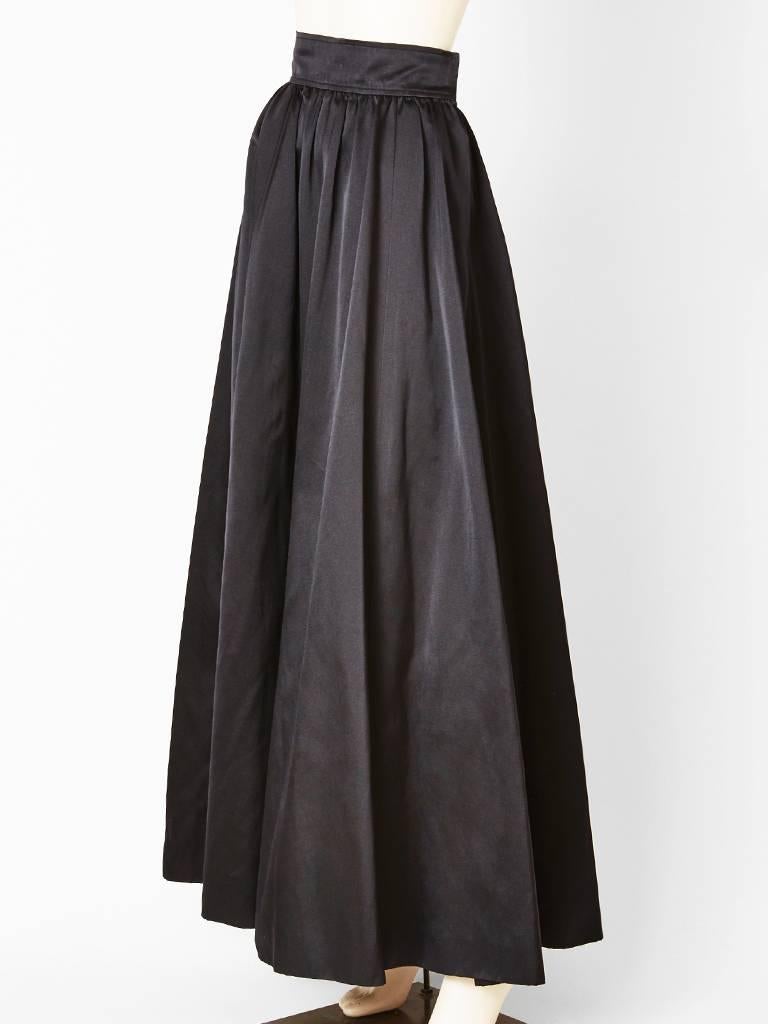 Yves Saint Laurent, black satin, long evening skirt, made of bias cut panels for fullness but without bulk at the waist. Slight gathering at the waistline with a 
wide waist band.
