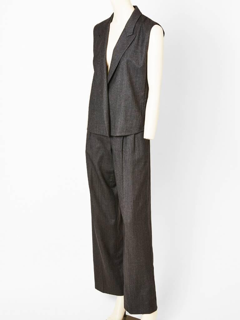 Hermes, grey flannel, sleeveless, jacket and pant ensemble. Jacket has lapels
and hidden off center closure. Trouser is pleated with a straight leg.
Designed by Tan Giudicelli for Hermes.