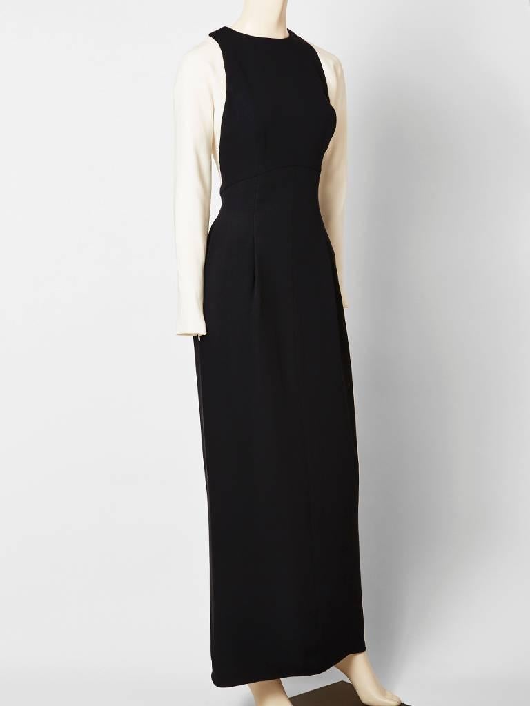 Geoffrey Beene, black and white crepe evening dress, having a jewel neckline, long sleeves and a semi dropped waist. Black, bodice is semi fitted with a 