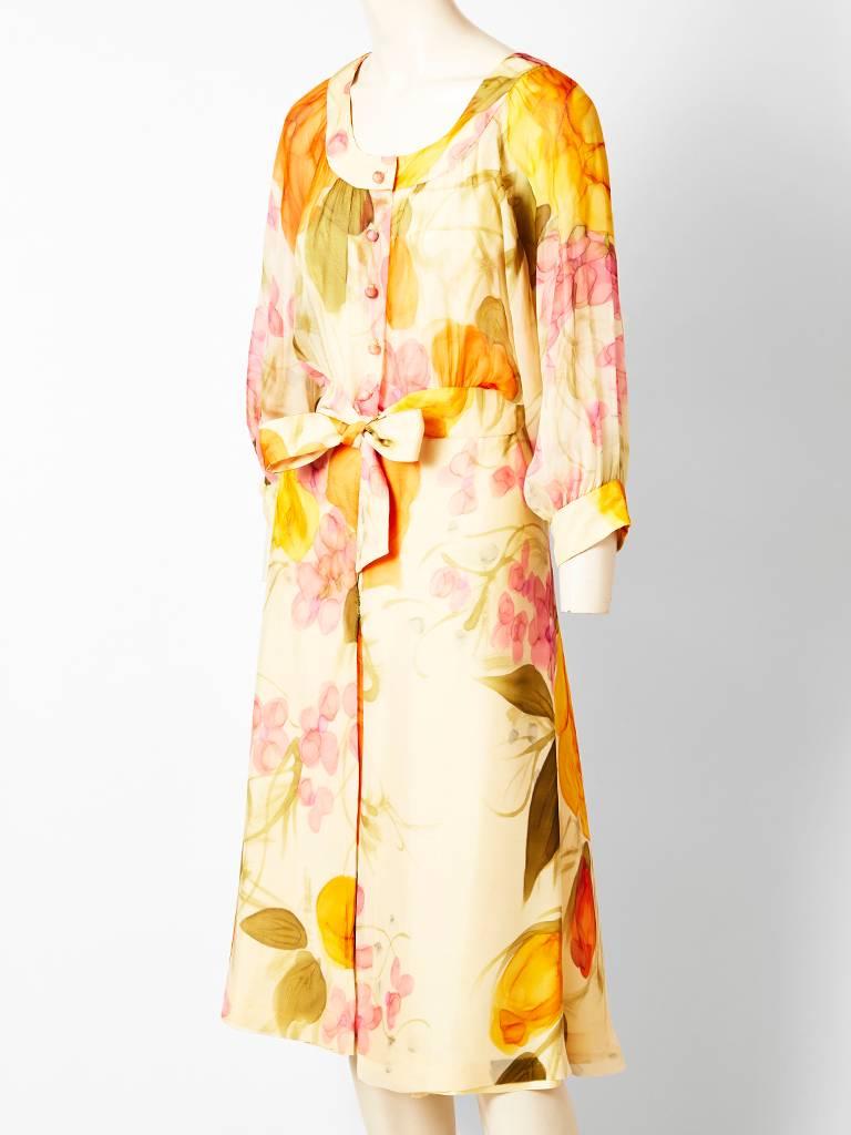 Eric de Juan, pastel tone, floral, print, chiffon day dress. c.1970's.
Having a scoop neckline, with sheer dolman sleeves that are cuffed at the wrist. Self buttons going down to the waist with an attached belt to be tied at the center front. Skirt