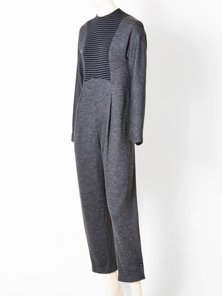 Geoffrey Beene, grey, wool knit, jumpsuit, with a horizontal, stripe bib detail at the bodice.
Long, sleeves, jewel neckline, semi fitted at the waist, front pleats , button detail
at the cuff of pant.