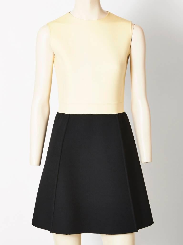 Mila Schon, black double face wool dress and jacket ensemble. Dress is sleeveless with an ivory fitted bodice and black structured A line skirt with seam
details. Jacket is cropped to just above the hip having a small collar and a front panel of
