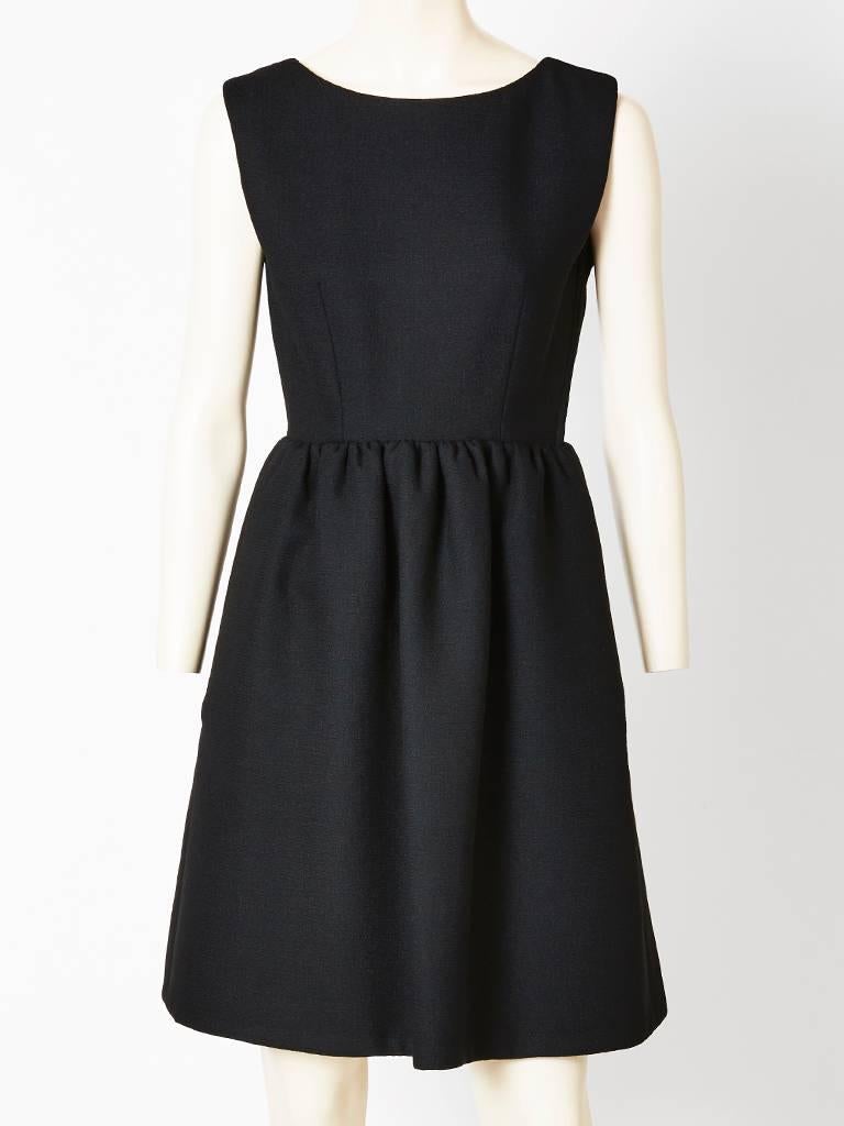 Norman Norell, heavy, wool crepe, sleeveless dress and dinner jacket ensemble.
Dress has a scoop neckline, with a fitted bodice and gathered skirt with hidden side pockets. Jacket is double breasted, having jeweled buttons and a semi fitted bodice