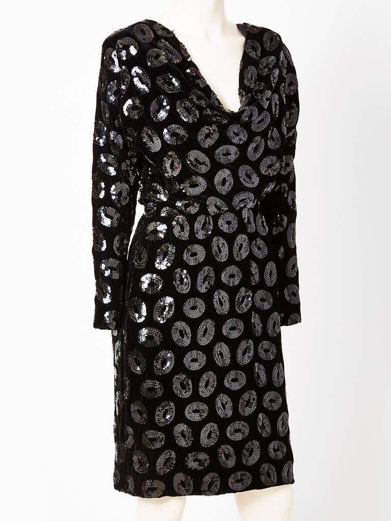 Givenchy Couture, black velvet cocktail dress having black sequins embellishment in the form of circles. Dress has long  sleeves with a cowl, draped neckline having an interior 