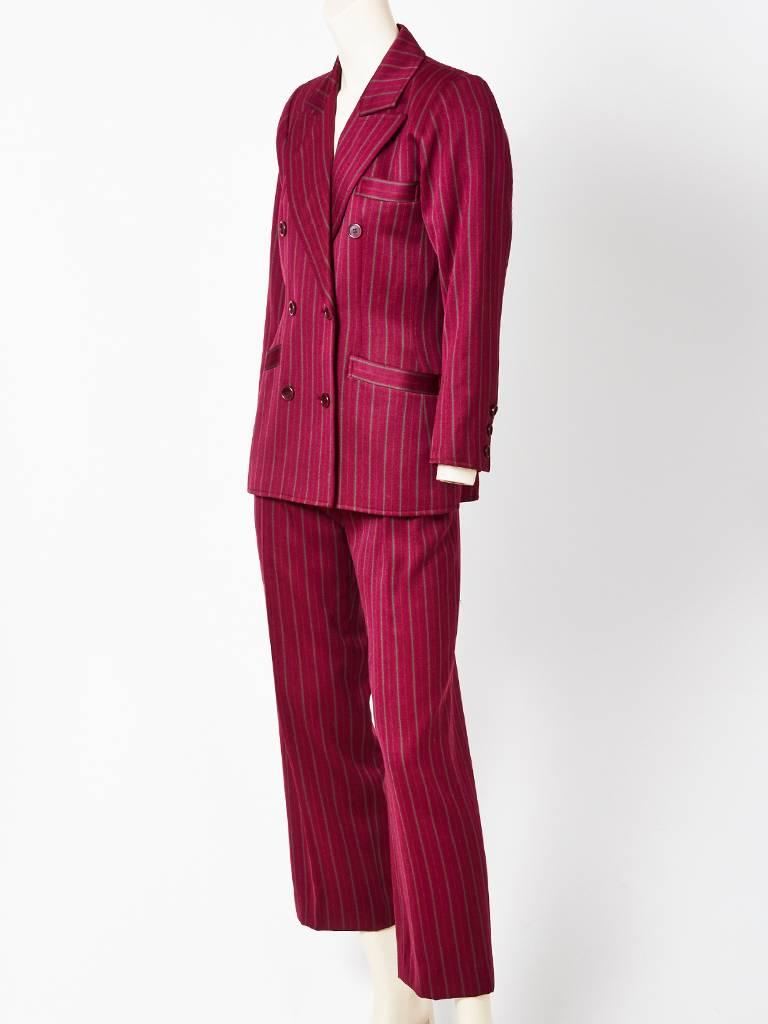 Yves Saint Laurent, burgundy, wool gaberdine, pin stripe, double breasted pant suit. Jacket has a semi fitted waist and falls below the hip. Trouser is mens wear style with a fly front, front pleats and side  pockets. Late 70's early 80's.