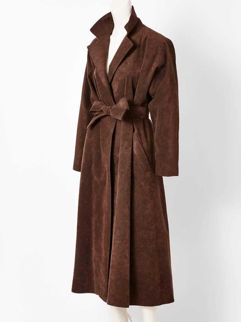 Halston, chocolate brown, ultra suede, belted coat, having a notched / lapel collar, no closures and a flared silhouette. The coat should wrap and stays closed with its self belt, Slash pockets at the hip.