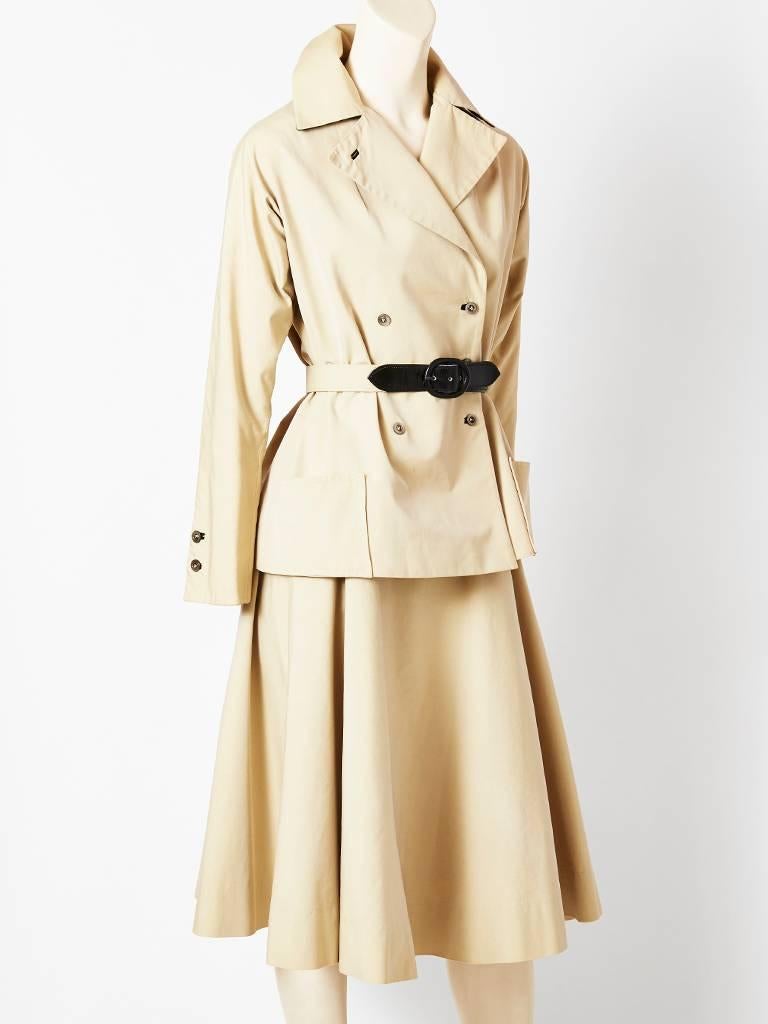 Women's Haberdasher's khaki safari inspired, skirt suit. Jacket has a belt with leather buckle detail. The lapels have a black underlining. The underlinning can be seen if you stand the collar up. Matching skirt is full.