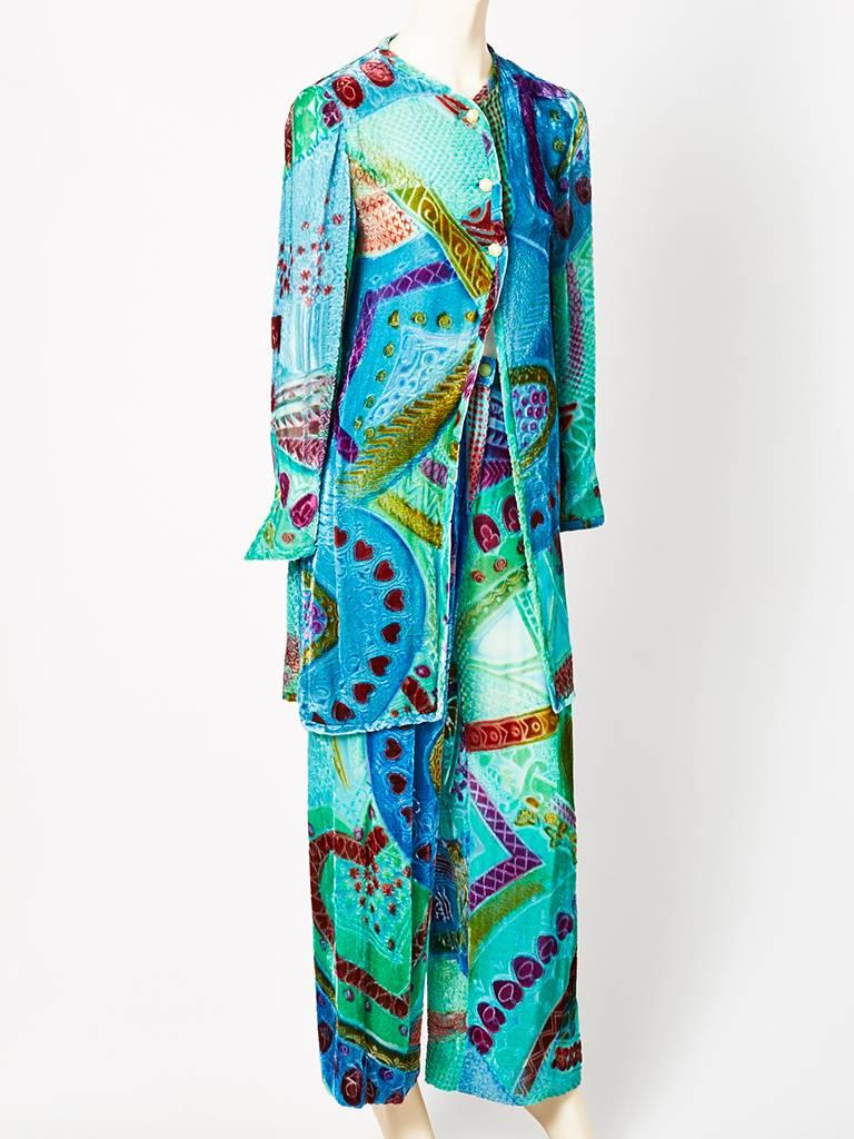 Colorful, cut velvet on chiffon, long tunic/jacket and a wide leg pant ensemble, C. 1970's. Lovely shade of aqua as the predominant color, having an abstract pattern, mixed with shades of purples and greens. Jacket is long, to the knee, having no