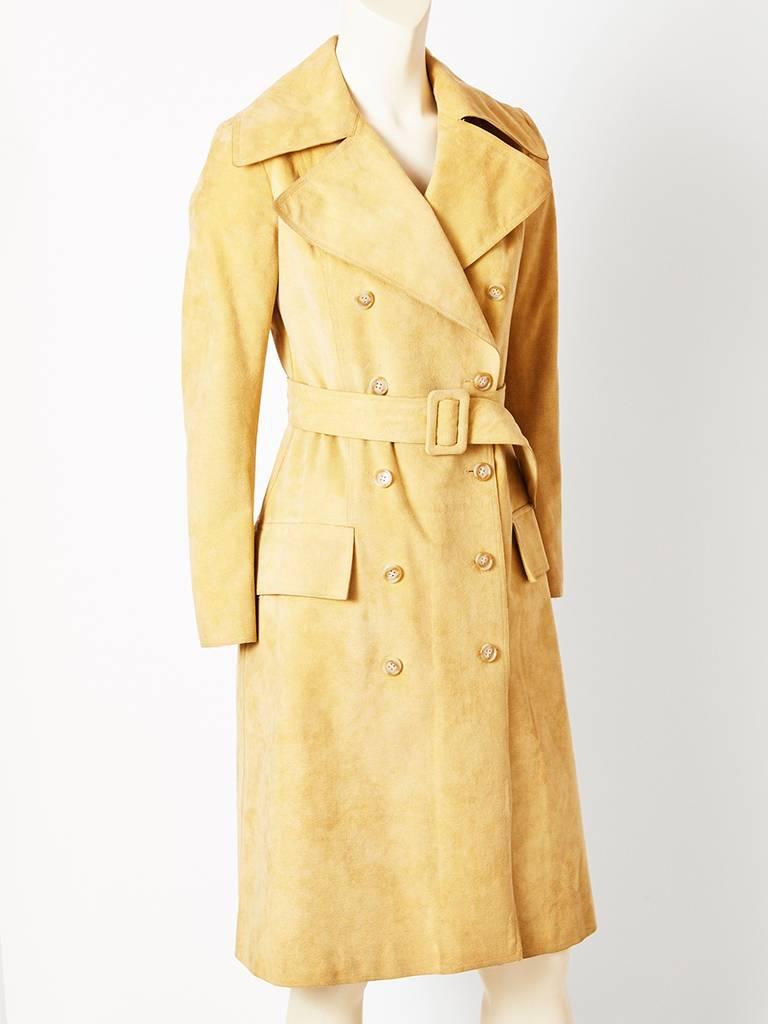 Halston, beige, ultra suede, double breasted, belted trench, having a fitted bodice, A line silhouette, wide lapels, and a back middle vent. C.1970's

 