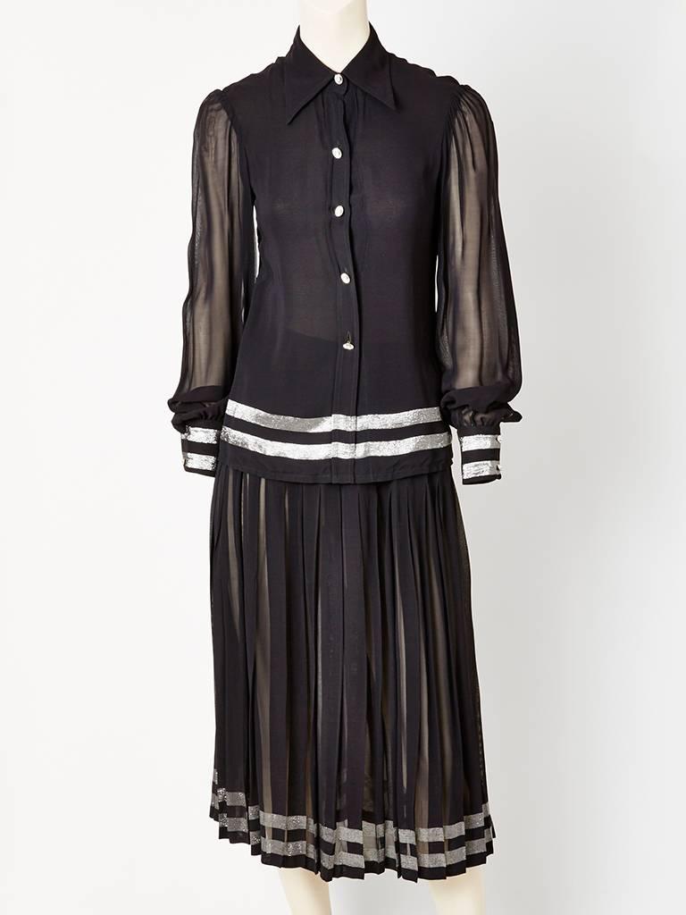 Sheer chiffon, blouse and pleated skirt ensemble with silver lame horizontal detail at the hem of blouse and skirt.  Matching scarf that can be also used as a belt. Blouse has a signature,  70's pointed shirt collar having diamainté buttons at the