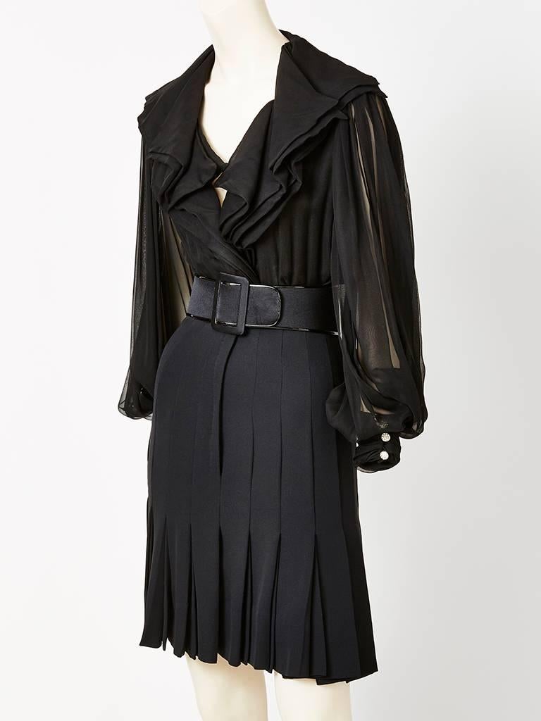Galanos, layered chiffon dinner dress, having sheer full sleeves that cuff at the wrist and a generous flounced collar. Silhouette is slim with box pleats that start above the knee and end at the hem ( below the knee). Wide belt at the waist