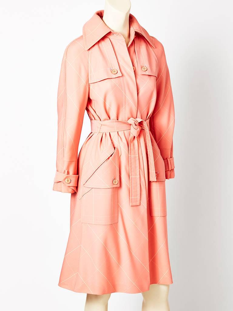 Valentino, pale salmon, gabardine, belted, trench-like coat having a plaid pattern and that is placed on the bias. Button detail on the pockets and bodice.
C. Late 70's.
