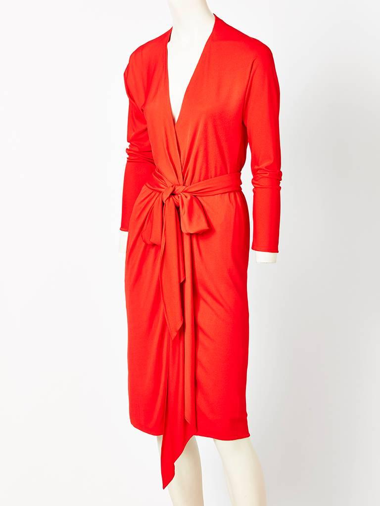 Halston, red, matte jersey, deep, V neck, wrap dress, having a generous self belt, that can wrap around the waist several times or left long. C. Late 70's.