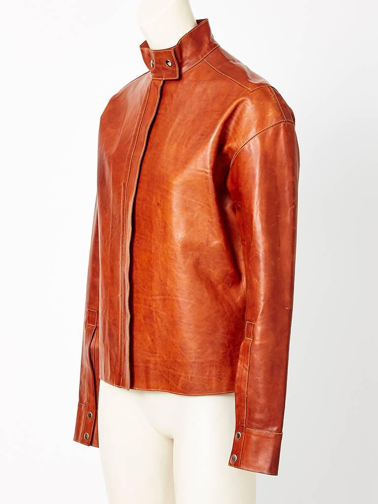 Yves Saint Laurent, luggage tone, leather, masculin style leather jacket ,
ending,  at the hip. This jacket has a high neck with snap closures, and a hidden zipper front closure. 
Never been worn... Needs some breaking in.