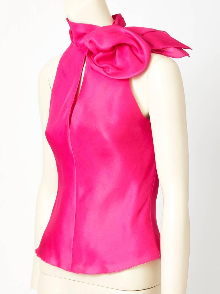 Jackie Rogers, fuchsia, organza, bias cut, halter blouse, having a high neckline with an organza, flower embellishment sitting at the left shoulder. There is a center slit from the neck dowm to the bustline, exposing a bit of skin. Back of 
blouse