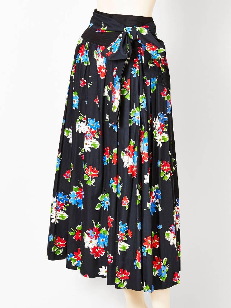 Yves Saint Laurent, cotton, multi toned, floral pattern, on black ground, gathered skirt, having a long tie that can wrap around the waist several times or left long.