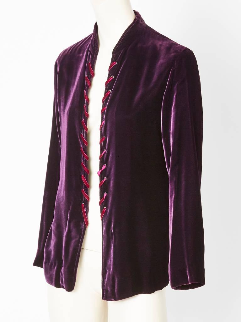 Yves Saint Laurent, Aubergine, velvet, jacket having a mandarin collar. There are no closures; jacket is to be worn open exposing the fuchsia lacing detail along the front edges. C. Late 70's early 80's.